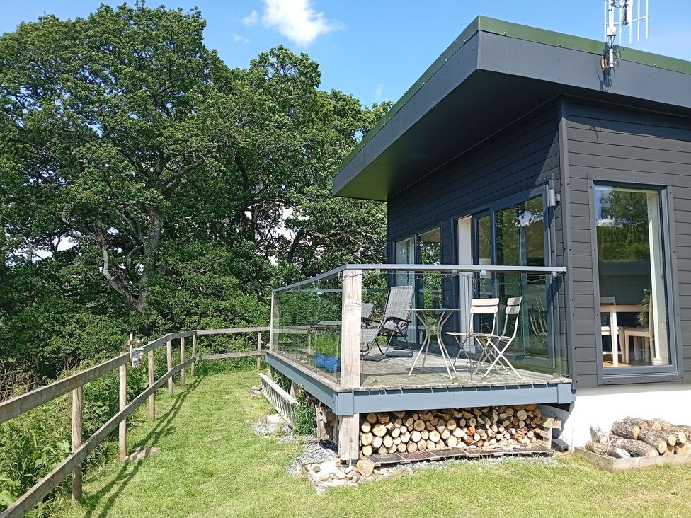 A deck with chairs and a table at Dundarach Aberfeldy