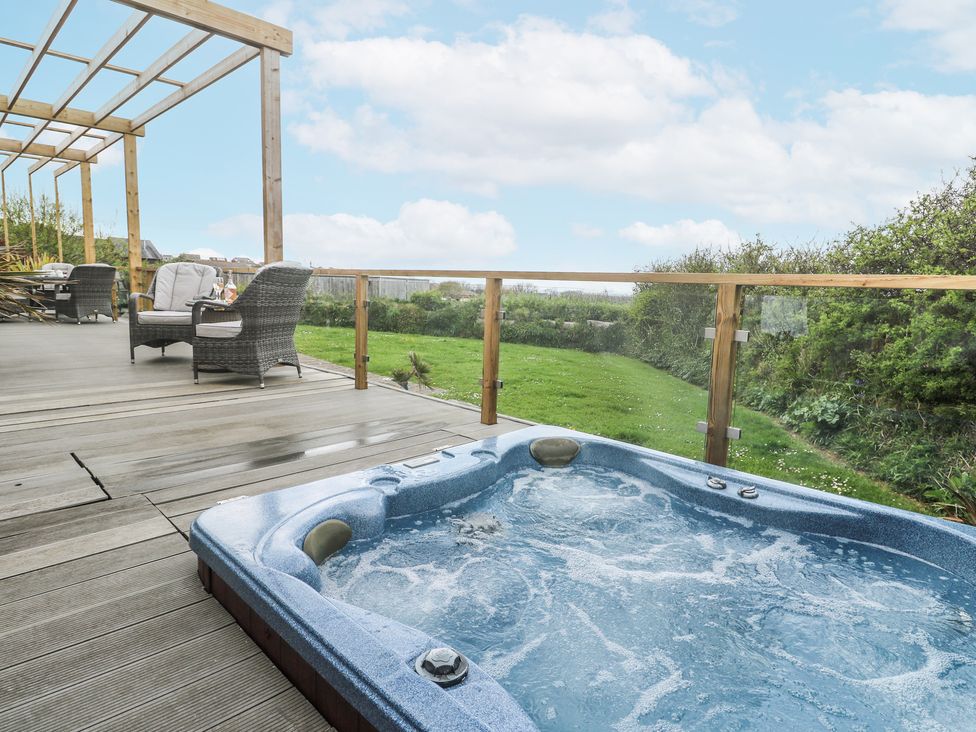 An outdoor space with a hot tub and seating area at Petroc in Portreath