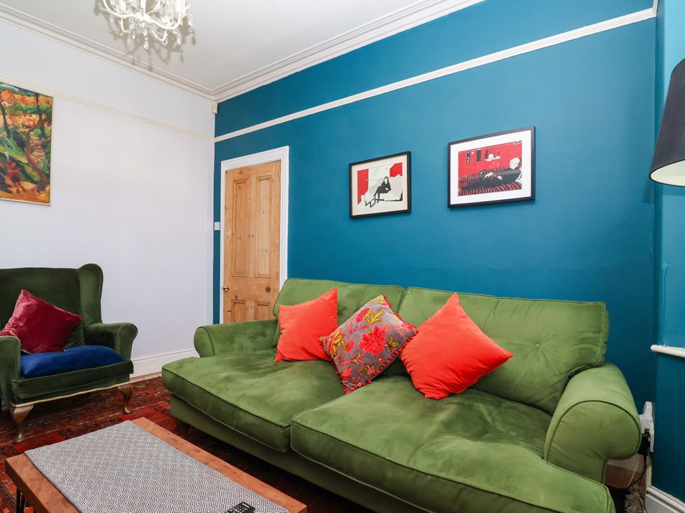 A living room with a green sofa and armchair at 45 Brook Lane in Chester