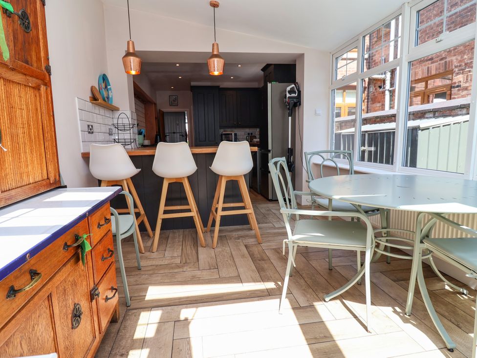 A kitchen with stools and a dining table at 45 Brook Lane in Chester