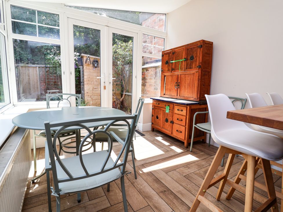 A conservatory with a table and chairs at 45 Brook Lane Chester