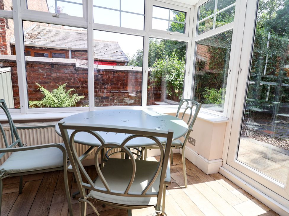 A conservatory with a table and chairs at 45 Brook Lane Chester