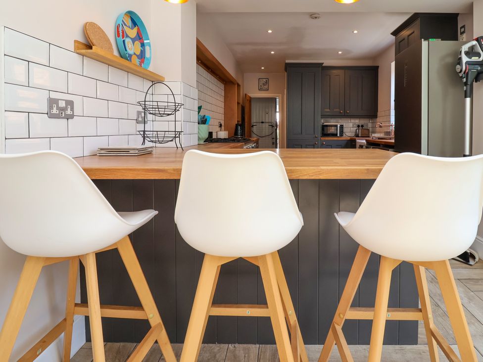 A kitchen with bar stools and counter at 45 Brook Lane in Chester