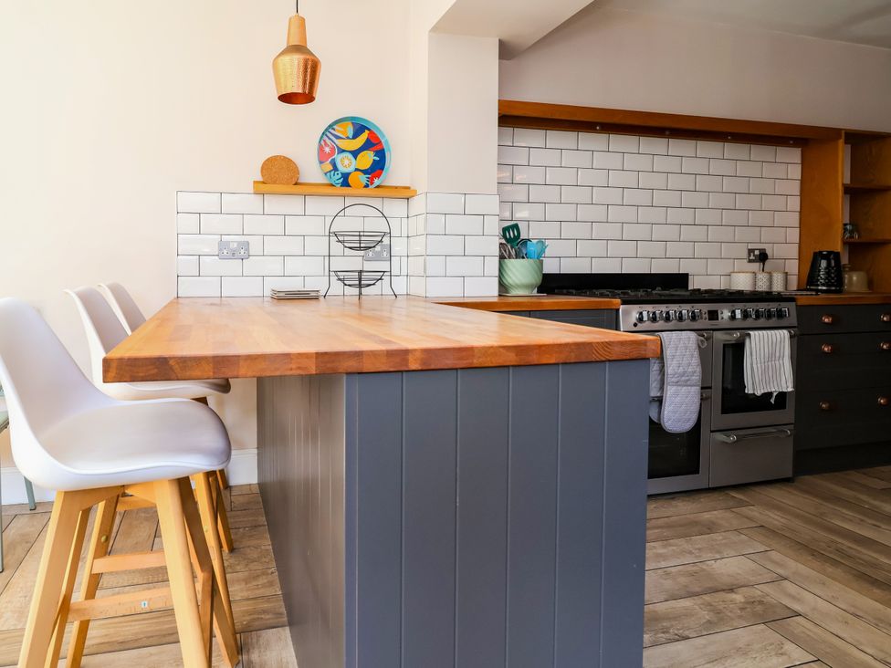 A kitchen with a wooden island and seating at 45 Brook Lane Chester