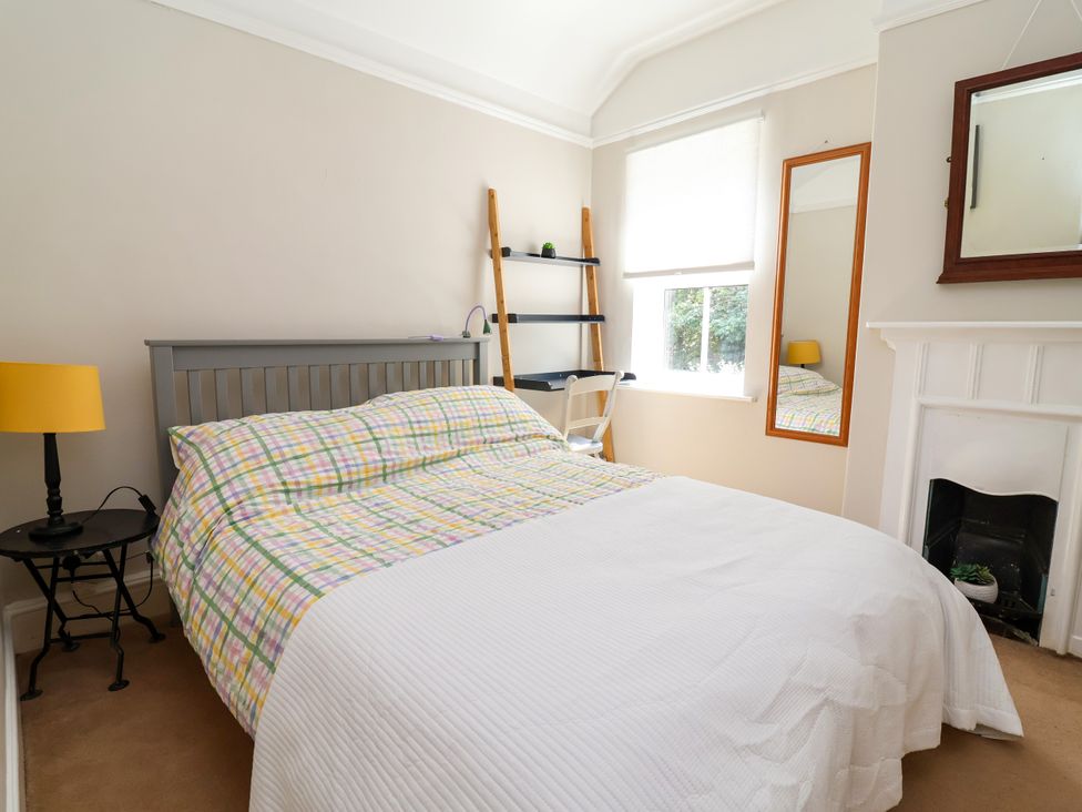A bedroom with a bed, lamp, and shelf at 45 Brook Lane Chester
