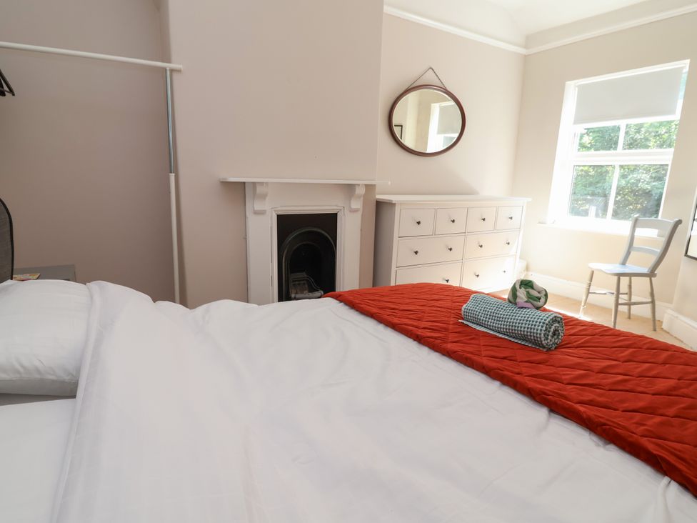 A bedroom with a bed, dresser, and mirror at 45 Brook Lane Chester