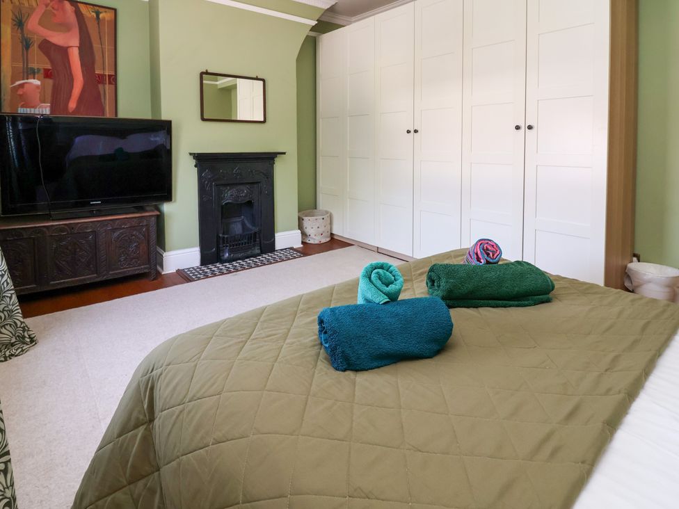 A bedroom with a bed, towels on the bed, and a television at 45 Brook Lane Chester