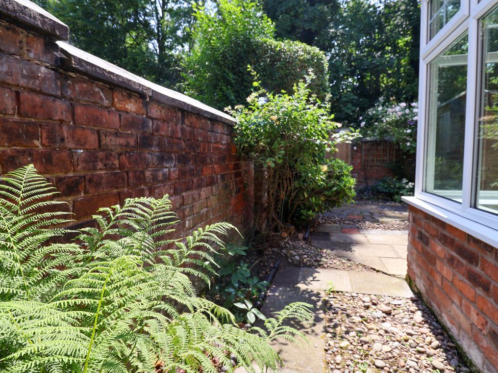 A garden with a pathway next to a brick wall at 45 Brook Lane Chester