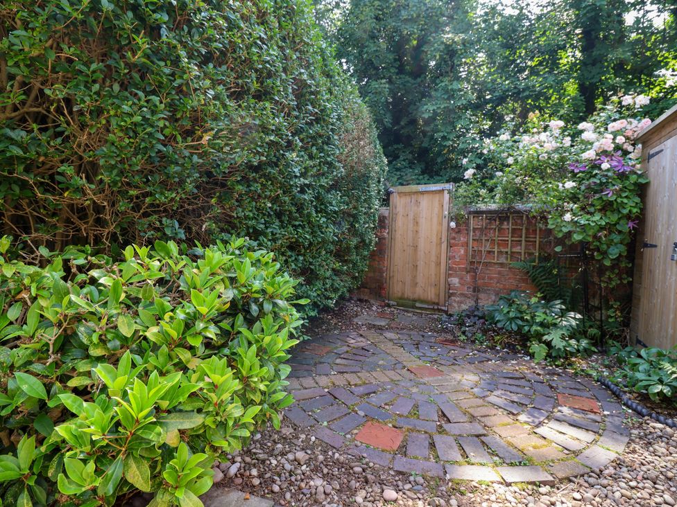 A garden with a stone pathway and a wooden gate at 45 Brook Lane Chester