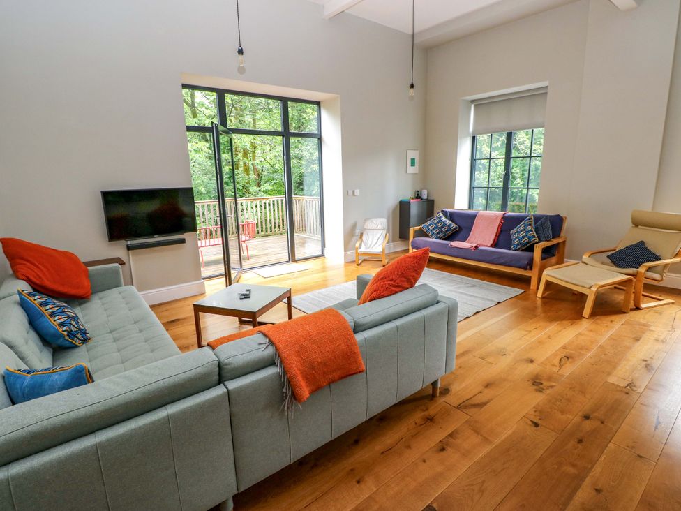A living room with sofas and a television at The Old Creamery in Ffairfach