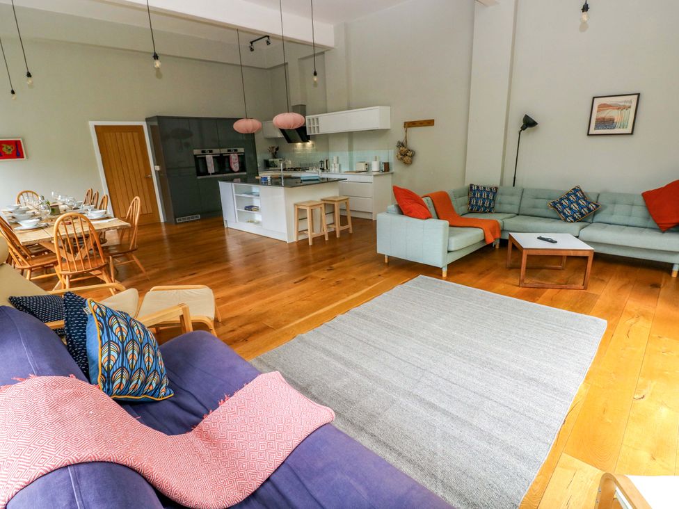 A living room with a sofa and dining area at The Old Creamery in Ffairfach