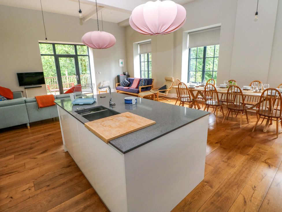 A kitchen with a dining area and a sofa at The Old Creamery in Ffairfach