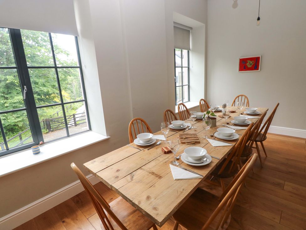 A dining room with a wooden table and chairs at The Old Creamery in Ffairfach