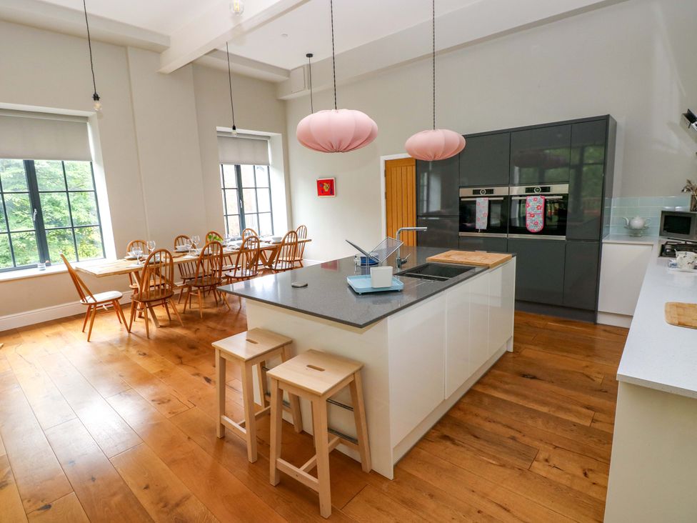 A kitchen with a dining area and a cooking island at The Old Creamery in Ffairfach