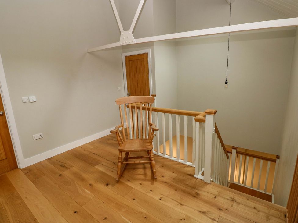 A landing with a chair and stairs at The Old Creamery Ffairfach
