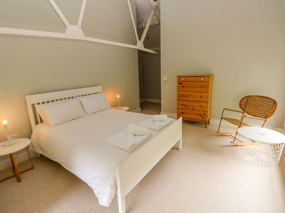 A bedroom with a bed and wooden furniture at The Old Creamery in Ffairfach