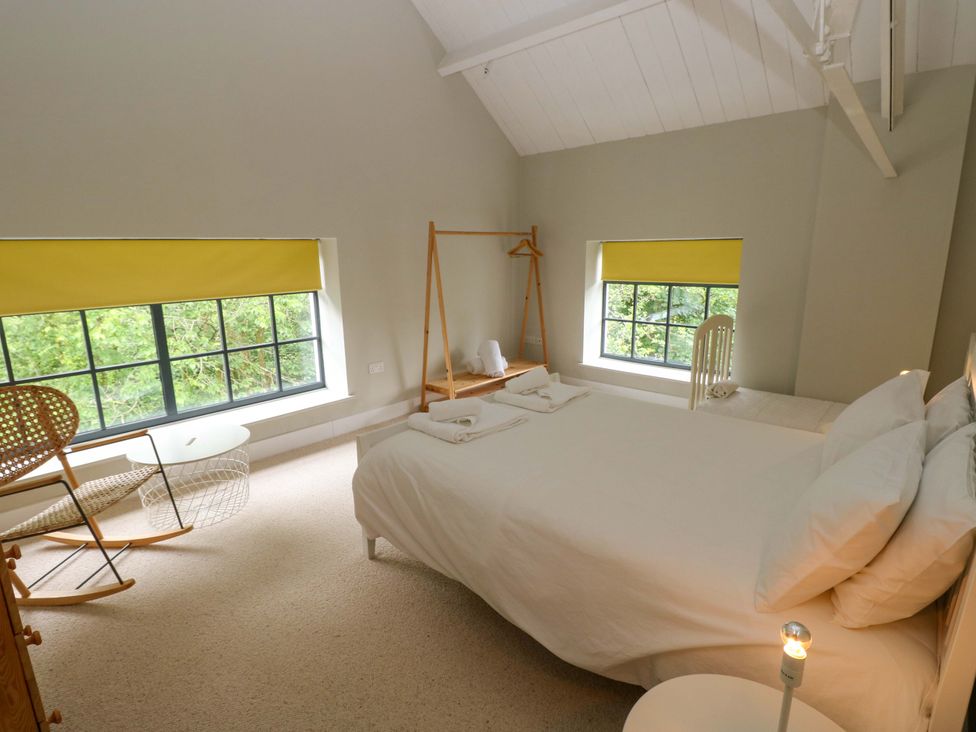 A bedroom with a bed and window at The Old Creamery in Ffairfach