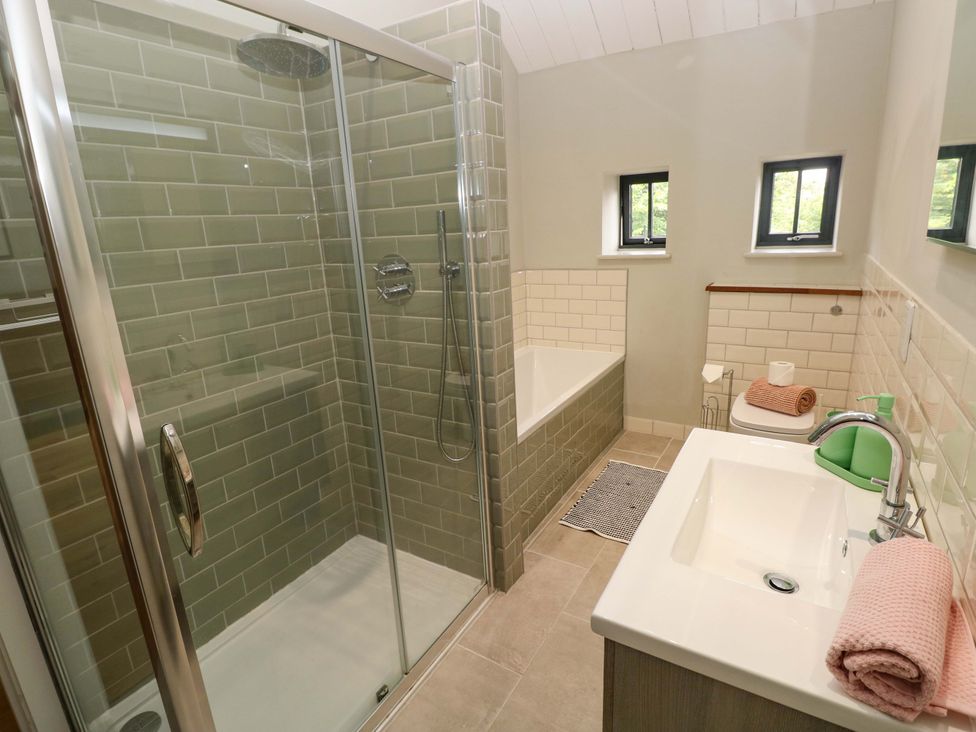 A bathroom featuring a shower, bathtub, sink, and toilet at The Old Creamery in Ffairfach