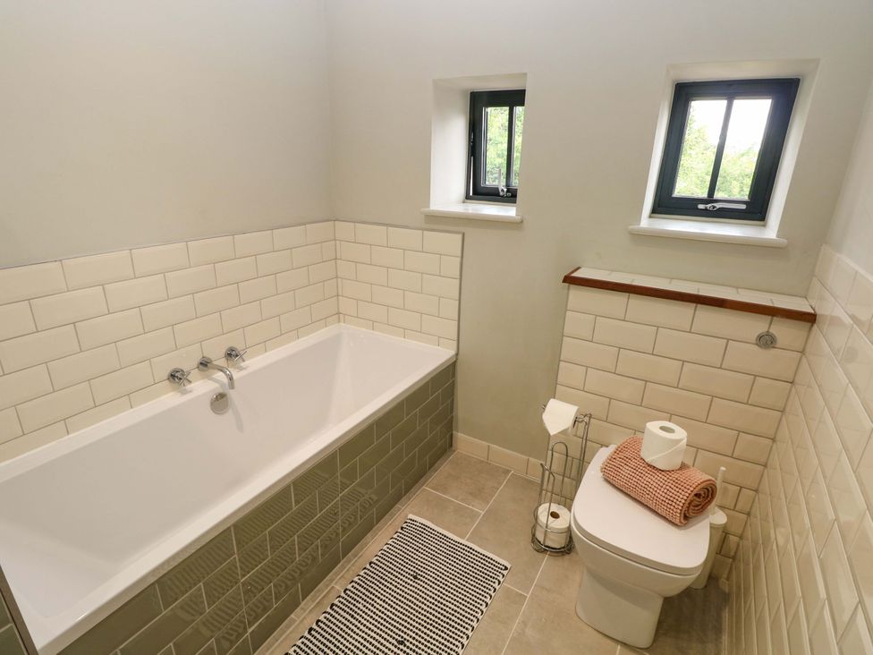 A bathroom with a bathtub and toilet at The Old Creamery in Ffairfach