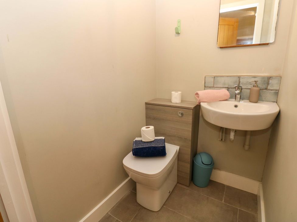 A bathroom with a sink, toilet, and small cabinet at The Old Creamery in Ffairfach