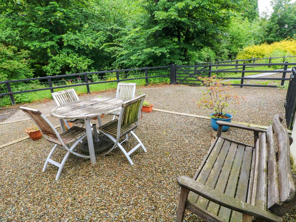 An outdoor area with a table and chairs beside a gravel surface at The Old Creamery Ffairfach