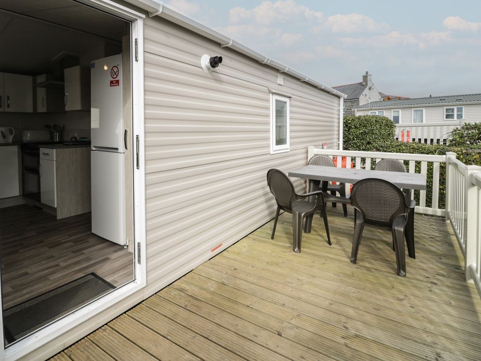 An outdoor deck with a table and chairs at Gold Caravan (316) Talybont