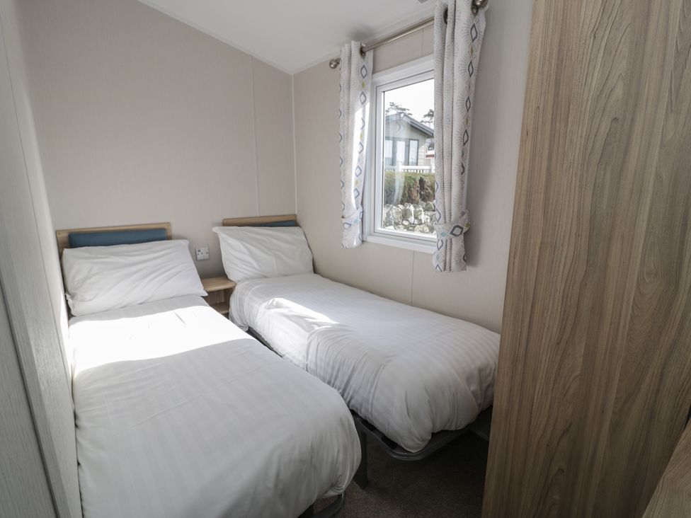A bedroom with two single beds and a window at Gold Caravan (203) Talybont