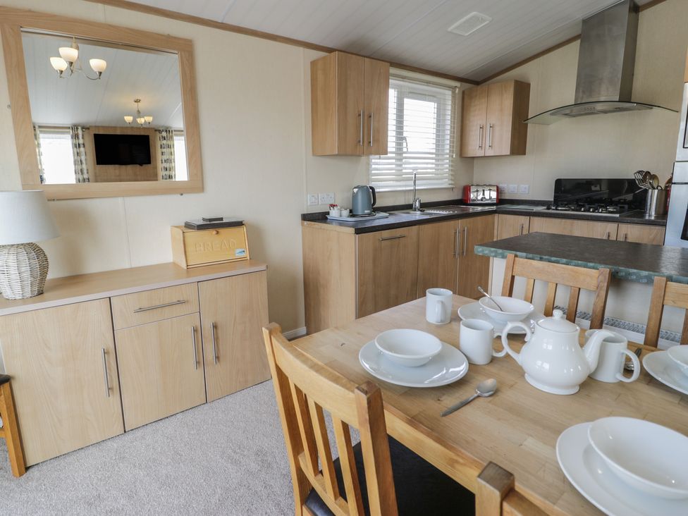 A dining area with a table set in Gold Lodge (201) Talybont