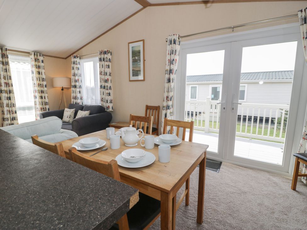 A living room with a dining table and sofa at Gold Lodge (201) Talybont