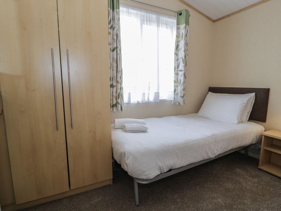 A bedroom with a single bed and wardrobe at Gold Lodge (201) Talybont