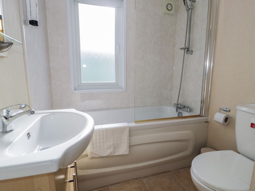 A bathroom featuring a bathtub, sink, and toilet at Gold Lodge (201) Talybont
