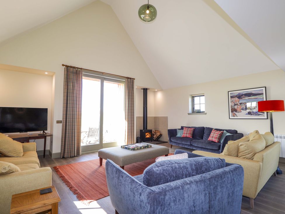 A living room with a television, sofas, and a fireplace at The Mandrel in Portmahomack