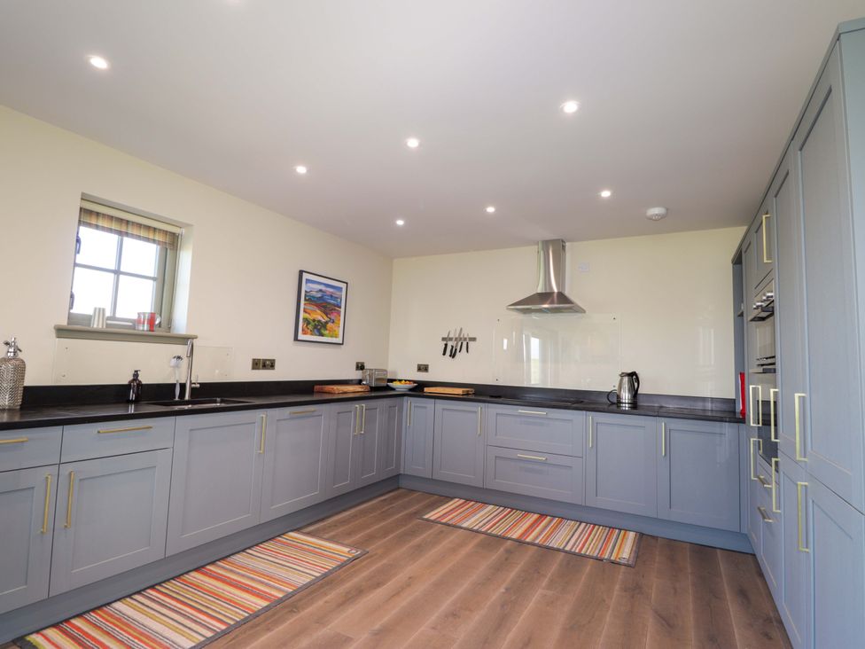 A kitchen with cabinets, sink, and stove hood at The Mandrel in Portmahomack