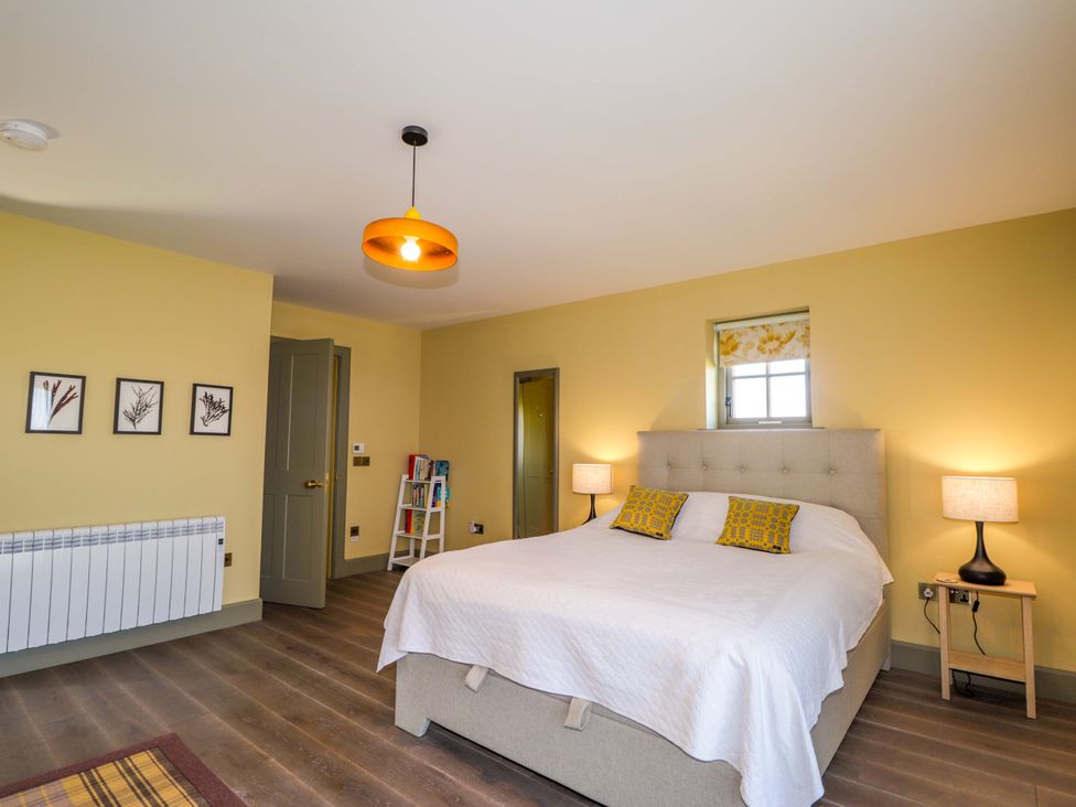 A bedroom with a bed and lamps at The Mandrel in Portmahomack