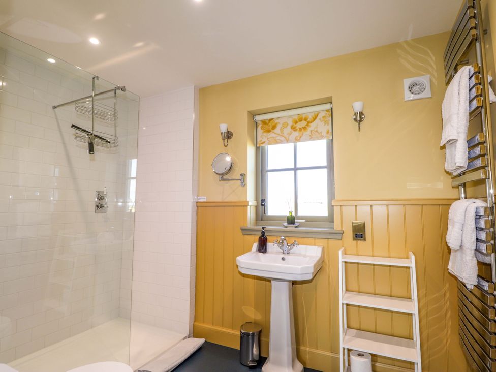 A bathroom with a shower, sink, and towel rack at The Mandrel in Portmahomack