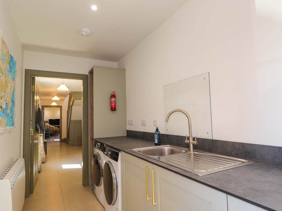 A laundry room with a washing machine and sink at The Mandrel in Portmahomack