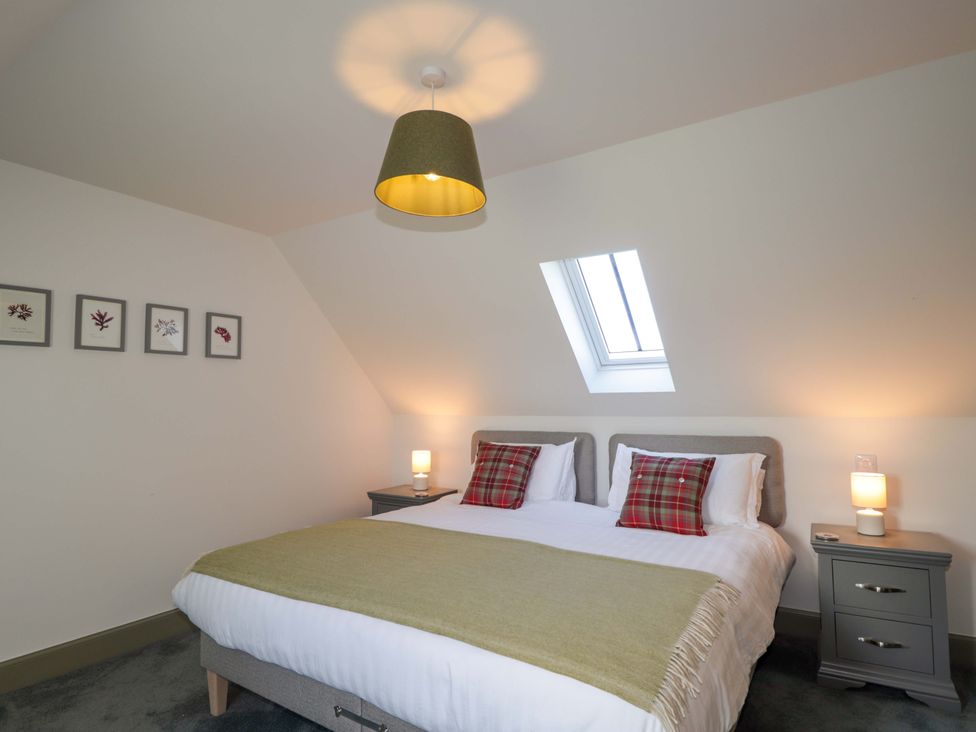 A bedroom with a bed and nightstands at The Mandrel in Portmahomack