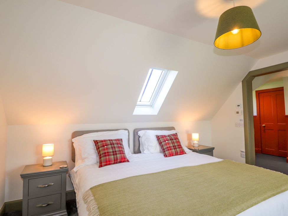 A bedroom with a bed and nightstands at The Mandrel in Portmahomack