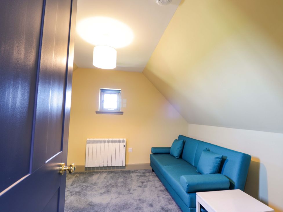 A living room with a sofa and lamp at The Mandrel in Portmahomack