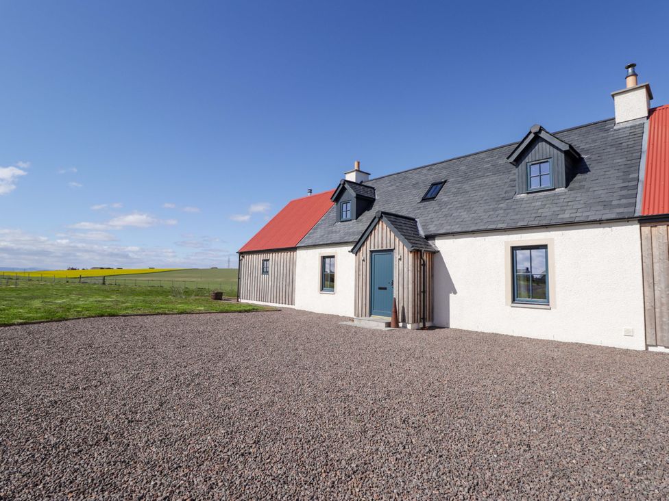 A house with a red roof and gravel driveway at The Mandrel in Portmahomack