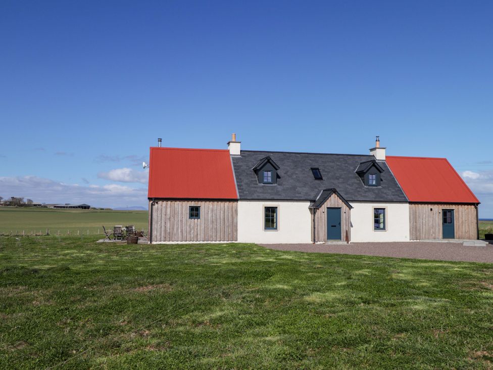 A house with a red roof and wooden panels at The Mandrel in Portmahomack