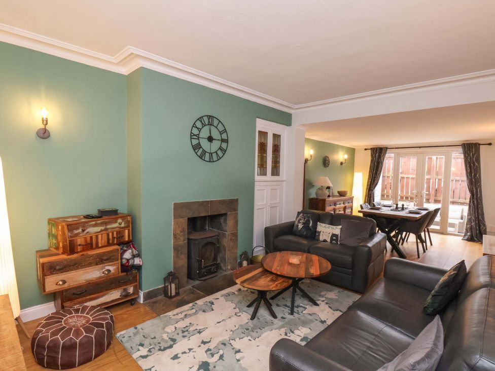 A living room with a sofa, table, and fireplace at Falcon's Nest in Whitby