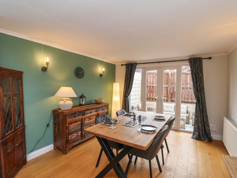 A dining room with a table and chairs at Falcon's Nest in Whitby