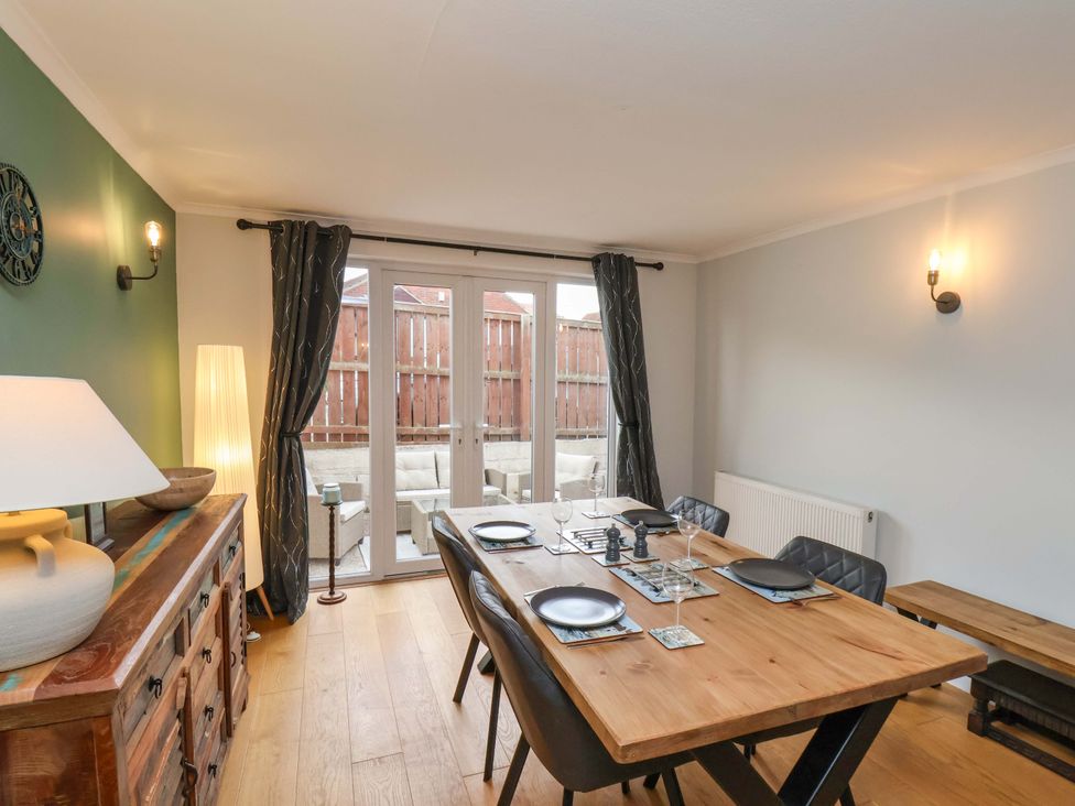 A dining room with a wooden table and chairs at Falcon's Nest in Whitby