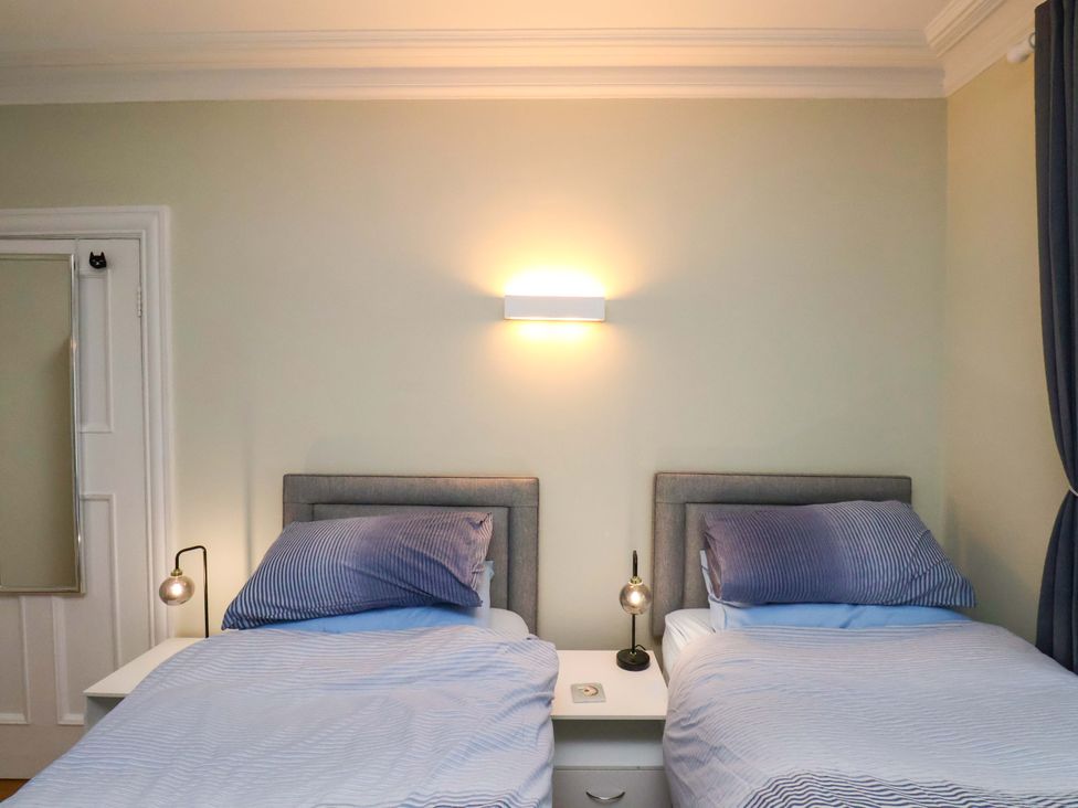 A bedroom with two single beds and a bedside table at Falcon's Nest in Whitby