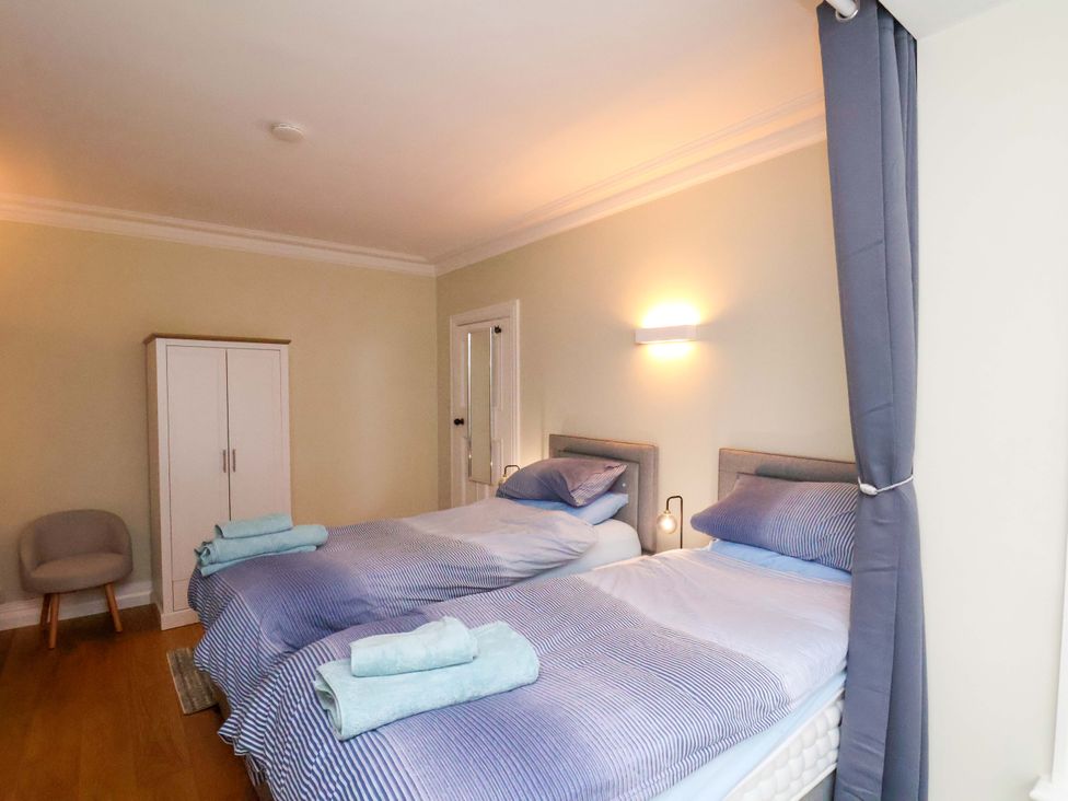 A bedroom with two beds and a wardrobe at Falcon's Nest in Whitby