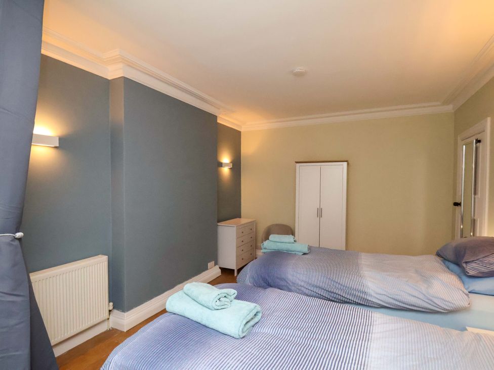 A bedroom with twin beds and a wardrobe at Falcon's Nest in Whitby
