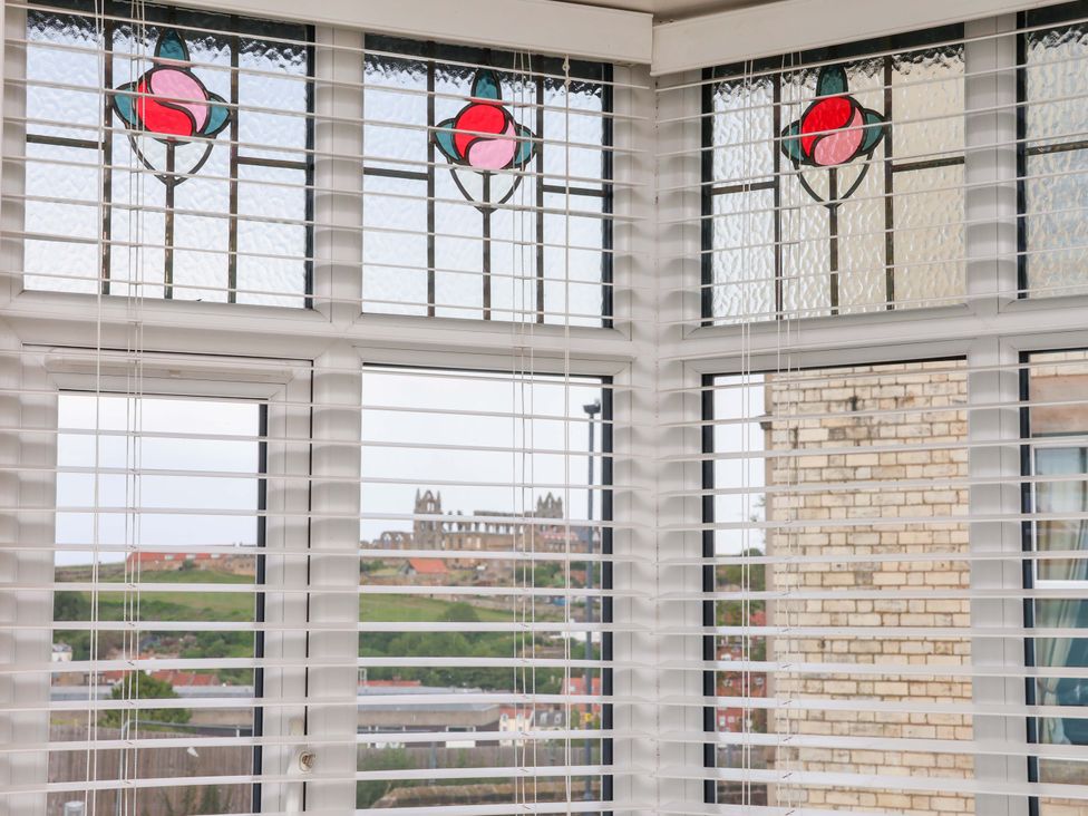 A conservatory with stained glass windows and a view outside at Falcon's Nest in Whitby