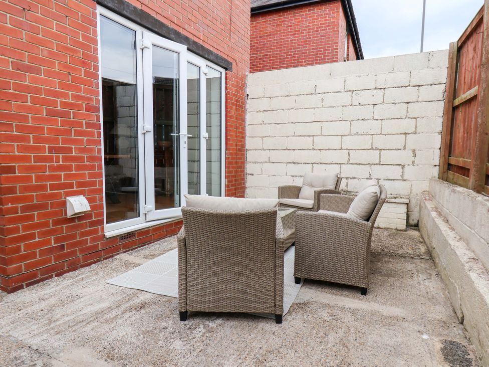 An outdoor patio area with armchairs and a table at Falcon's Nest in Whitby