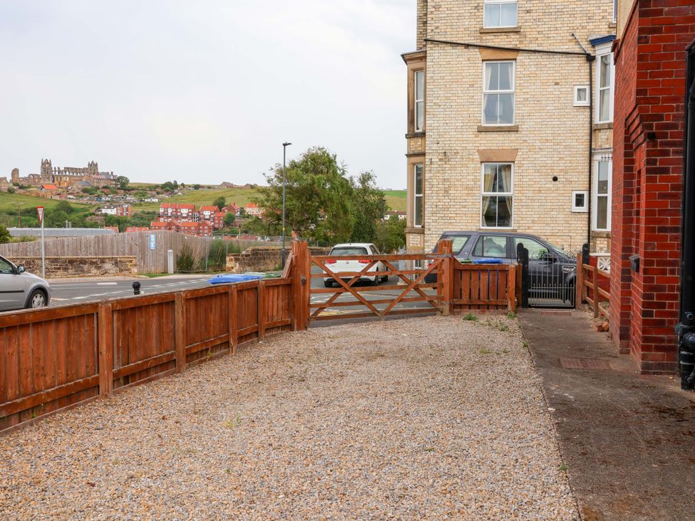 An outdoor area with a gravel driveway and parked cars at Falcon's Nest in Whitby
